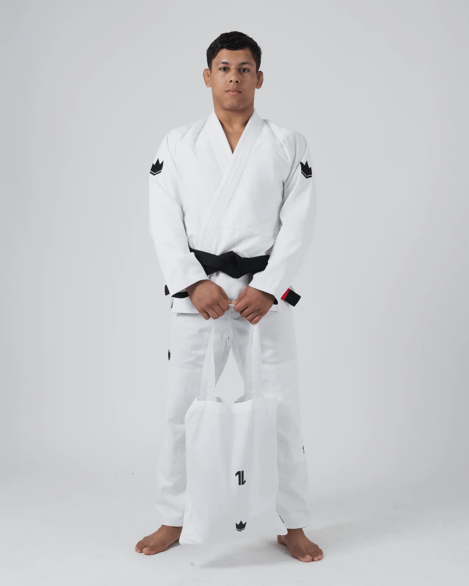 Kimono Brazilian Jiu Jitsu KINGZ The One V2 Alb poza facuta pe un model din fata incluzand si saculetul cadou pentru transportarea si depozitarea kimonoului